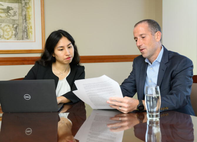 Emily Tanji and Dan Janis sitting at a conference table